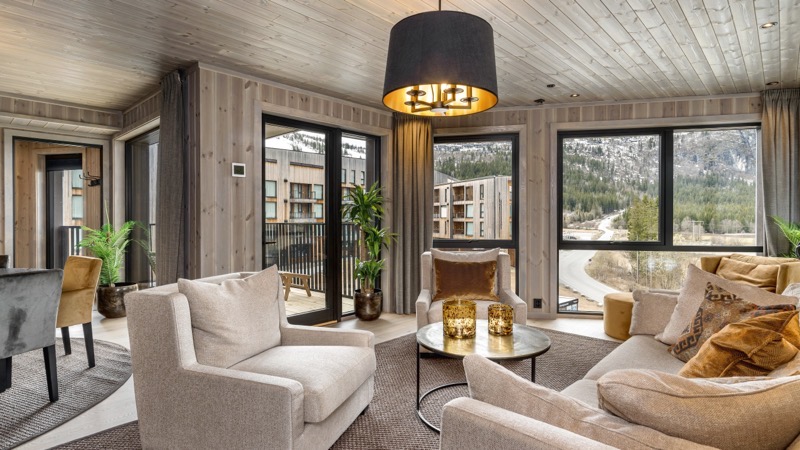 Stuen i leiligheten i Fjellandsbyen, med sofagruppe og store vinduer